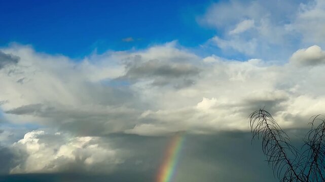 Rainbow over landscape. Rainbow over landscape under cloudy sky.