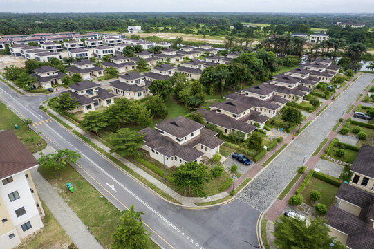 Aerial view of neat rows of houses with brown roofs stand in stark contrast to the lush green trees and well-paved roads, Ibeju Lekki, Lagos, Nigeria.