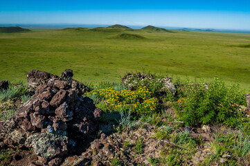 Zerkl&uuml;ftetes und verwittertes Steingebilde auf einer Anh&ouml;he in der Grassteppe im Osten der Mongolei, Zentralasien, bei sonnigem Sommerwetter