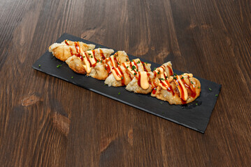 Different types of gyozas, such as vegetable or chicken, neatly arranged next to a small bowl of dark dipping sauce.
