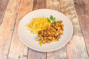 A combination plate with fried sweetbreads, simple fried potatoes, and fried green peppers, all together, showcasing a hearty and traditional meal