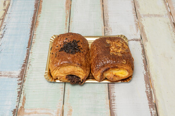 An irresistible close-up of the moment a pastry is split in half, releasing a stream of melted dark chocolate and vanilla cream