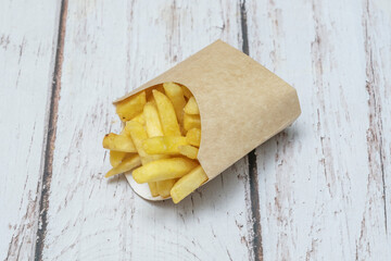 A serving of double-fried Belgian fries, served in a paper cone with a wooden spoon, topped with truffle mayonnaise and freshly chopped chives