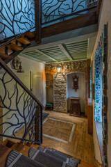 Rustic hallway interior with tree branch wrought iron stairs and brick wall