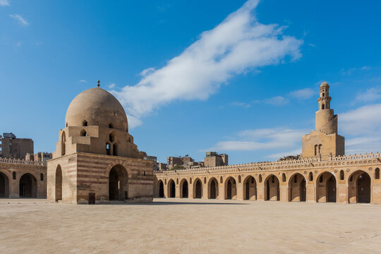Ibn Tulun Mosque in Cairo features a large dome and intricate architectural details. The structure showcases Islamic design elements and historical significance. - Powered by Adobe