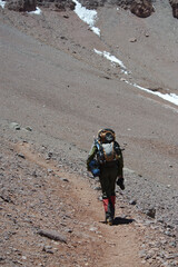 A lone climber climbs a slope in the snowy mountains in winter. Photographer in the mountains