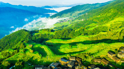 Aerial view of beautiful green terraced fields and village with mountain natural landscape in Guilin, China.