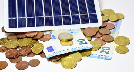 Renewable energy concept, in this case solar, panel and euros scattered on a light background.