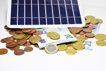 Renewable energy concept, in this case solar, panel and euros scattered on a light background.