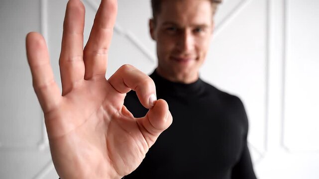 Confident Man Making OK Sign With Hand, Expressing Agreement and Satisfaction