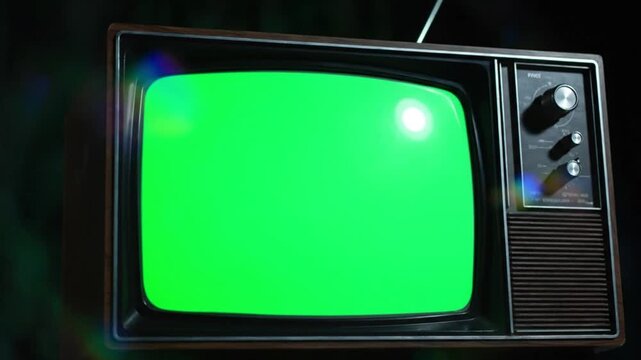 Close-up of an old television with a bright green tv green screen