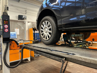 Close up of car inspection on a service lift in a garage.