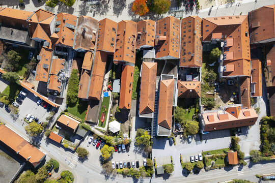 Aerial view of red tiled rooftops and buildings interweave with patches of green gardens, capturing the essence of urban life, Frohnleiten, Styria, Austria.