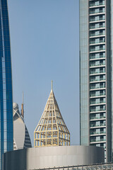 Dubai cityscape buildings with a golden lattice dome structure against a clear sky. Modern architecture and urban development concept. Dubai, UAE - 1 NOV 2023