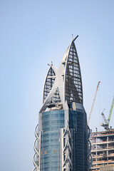 Modern skyscraper with unique architectural design under clear sky in Dubai. Urban development and majestic construction concept. Dubai, UAE - 1 NOV 2023