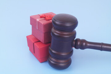 Red gift boxes with judge gavel on blue background. Prevention bribes as gifts concept.