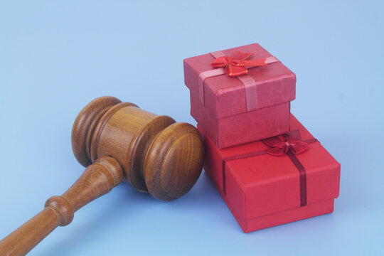 Red gift boxes with judge gavel on blue background. Prevention bribes as gifts concept. - Powered by Adobe