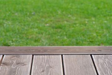 Empty rustic table top with blurred green grass landscape background. Abstract wooden counter. Mockup for promo, text or logo brand. Free space for text. Frame for display. Modern Presentation desk.