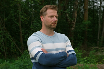 Handsome young man standing outdoors. Male thinking looking around feel happy, calm and serious....
