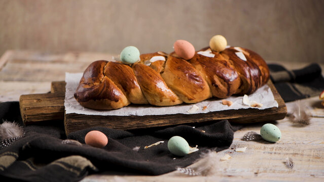 Braided Easter Bread with Pastel Speckled Eggs on Rustic Wooden Board
