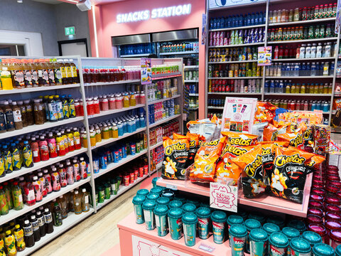 Snack aisle in Kenji store with juice bottles chips and colorful shelves at snacks station