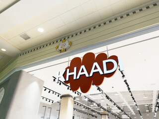 Naklejka premium Khaadi store sign inside a Manchester shopping mall with bright blue letters and decorative backdrop
