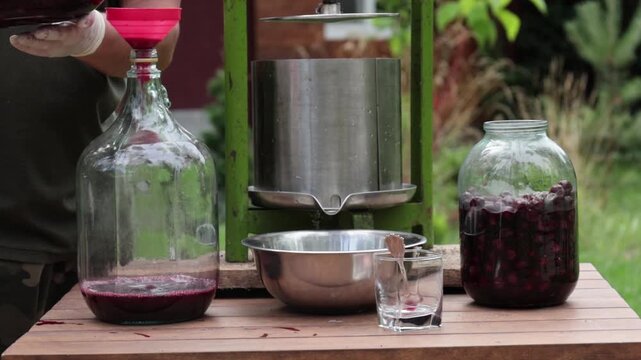 A man makes cherry juice in his garden