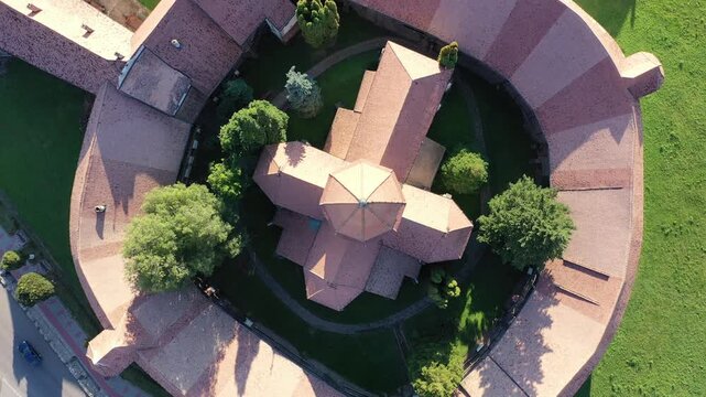 Aerial view of the fortified church, a captivating blend of red brick walls and lush green grass, a medieval fortress under the sun, Prejmer, Brasov, Romania.