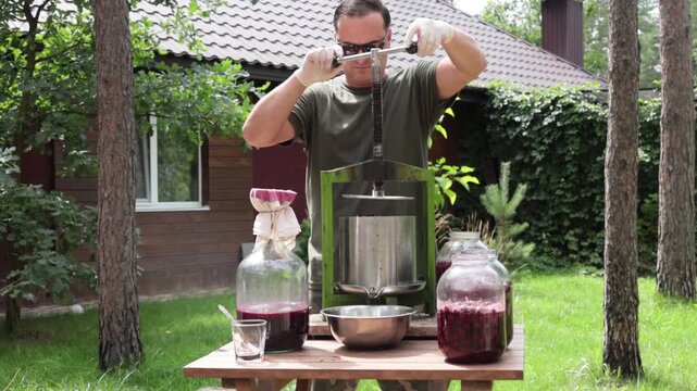 A man makes cherry juice in his garden