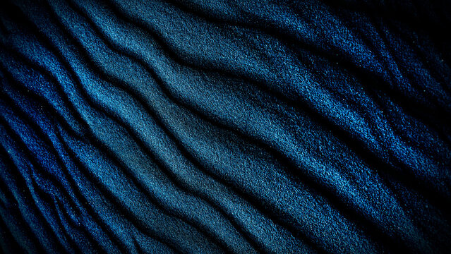 A macro closeup of a dark blue denim textile showing a detailed cotton fabric pattern and textured material surface for a fashion background or clothing wallpaper