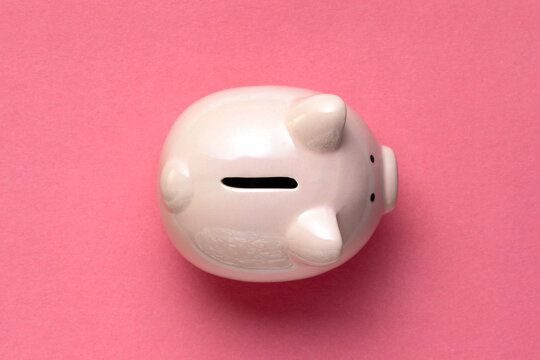 Ceramic pink piggy bank on pink background. Top view. Finance or banking concept.