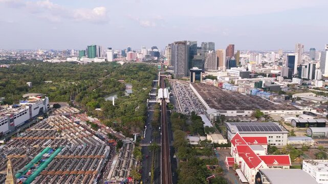Breathtaking aerial view capturing juxtaposition of expansive Chatuchak Weekend Market, lush park, and contemporary cityscape of Bangkok