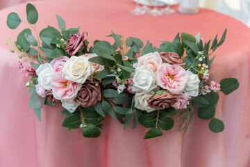 Obraz premium Floral decorations on a pink tablecloth at an event in a banquet hall during daytime