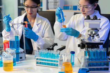 Scientists conducting research in a biotechnology lab, using pipettes and test tubes for medical and chemical experiments. Innovation in chemistry, healthcare, and medicine.