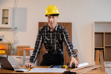 business man hand working and laptop with on on architectural project at construction site at desk in office.