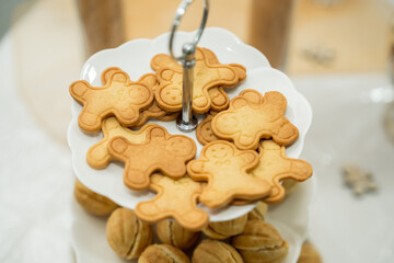 Gingerbread cookies displayed on a tiered serving tray at a festive gathering during winter season