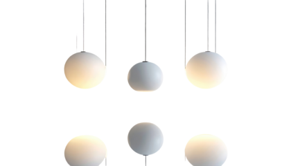 Six pendant lights glow against a black backdrop, hanging in a minimalist arrangement, with soft light