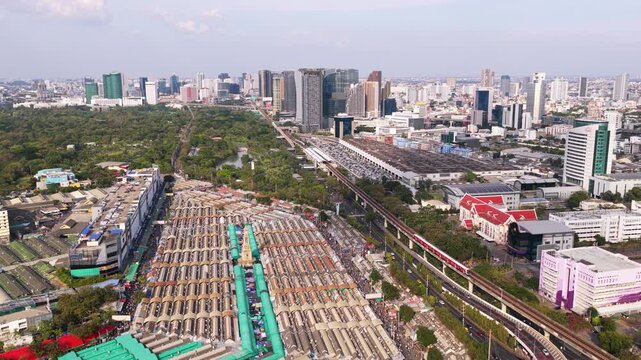 Panoramic aerial view of famous Chatuchak market in Bangkok. Amazing cityscape with modern skyscrapers and a park in background