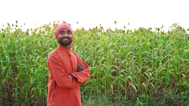 young indian farmer standing at agricultural farm