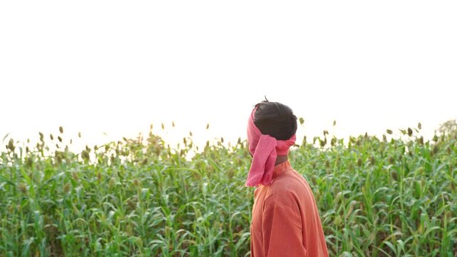 young indian farmer standing at agricultural farm