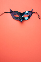 Sequin Masquerade Mask on Coral Background. Copy space