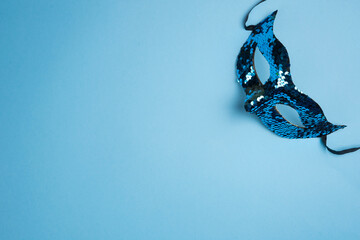Blue Sequin Masquerade Mask on Light Blue Background. Copy space