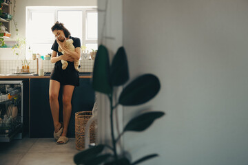 Mother holds baby in kitchen at home