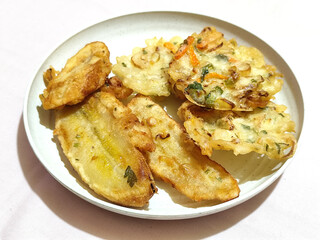 Gorengan, a traditional Indonesian street food consisting of fried bananas and bakwan (fried...