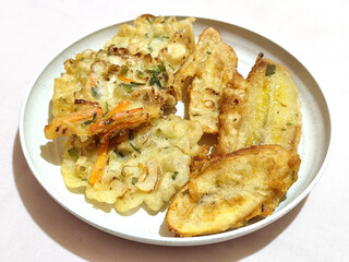 Gorengan, a traditional Indonesian street food consisting of fried bananas and bakwan (fried...