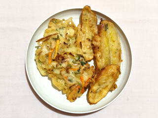 Gorengan, a traditional Indonesian street food consisting of fried bananas and bakwan (fried...