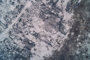 Destroyed residential neighborhood with ruined houses covered in snow illustrating war consequences...