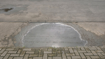 Rainwater puddles on the edge of the asphalt road.Ecological and environmental concepts. For graphic design, banners and 3D rendering