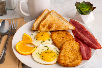 fried eggs  with  hash browns and turkey bacon