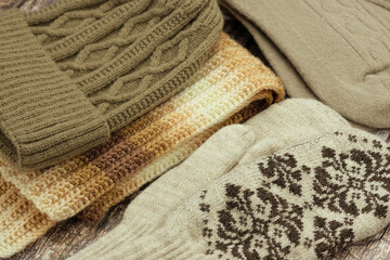 Fall and winter clothing. Close-up of a knitted hat, scarf, mittens, and socks. Warm clothing set.